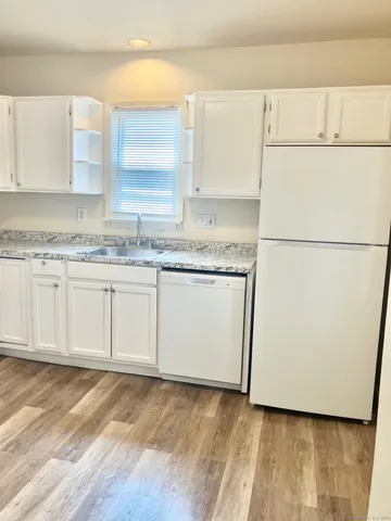 a view of a kitchen with sink and refrigerator