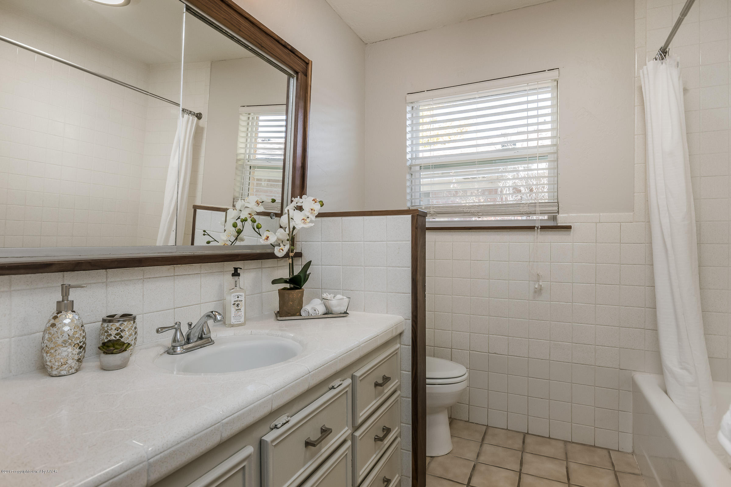 7208 Calumet Road Amarillo, TX 79106 - Photo 17 of 22 a bathroom with a granite countertop sink a toilet and a mirror
