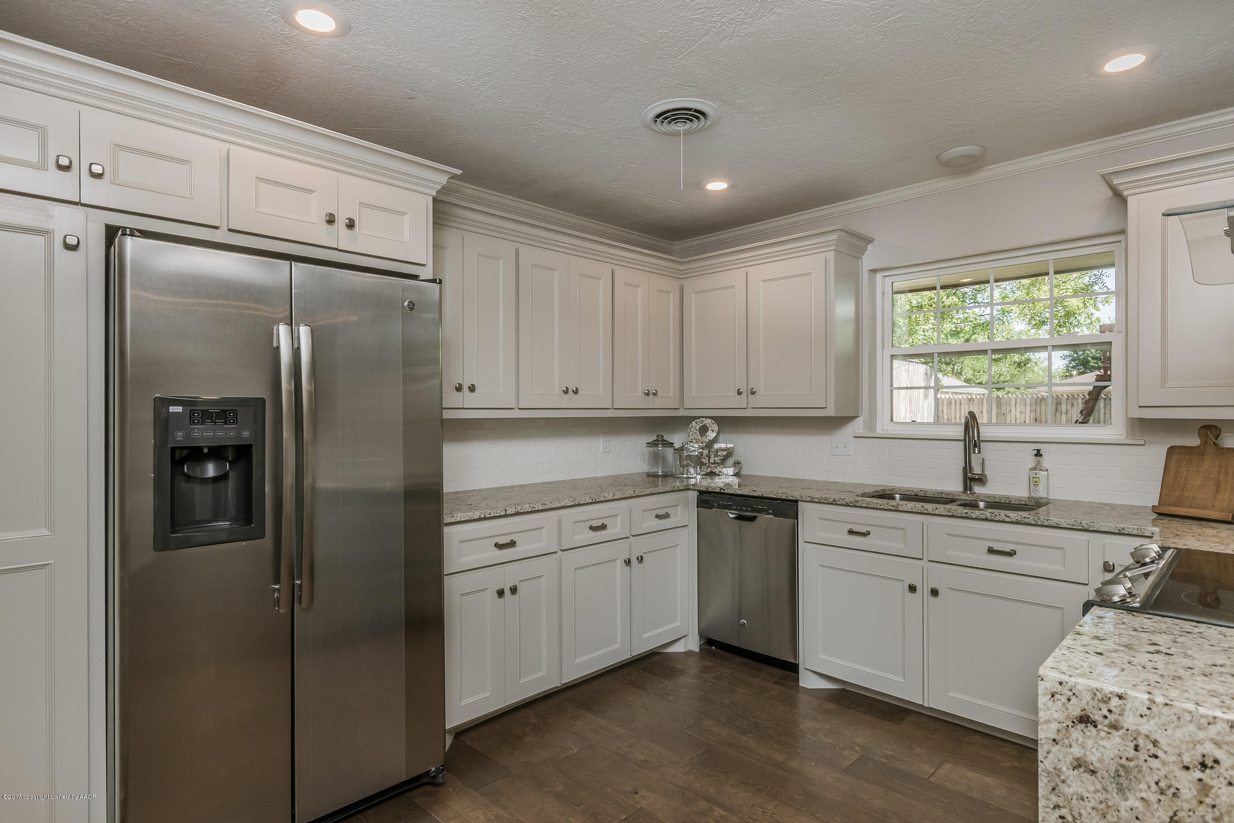 7208 Calumet Road Amarillo, TX 79106 - Photo 9 of 22 a kitchen with a refrigerator sink and cabinets