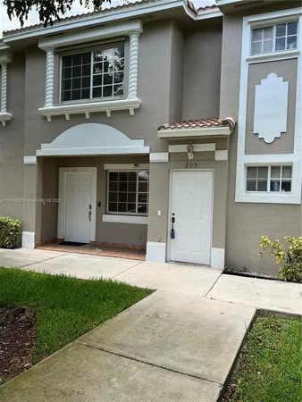 a front view of a house with a garden and garage