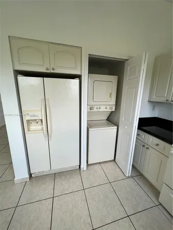 a kitchen with a refrigerator sink and cabinets