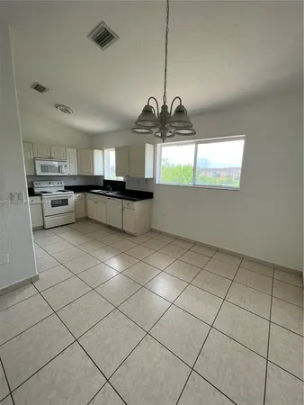 a kitchen with stainless steel appliances kitchen island granite countertop a refrigerator a sink a stove a microwave and cabinets