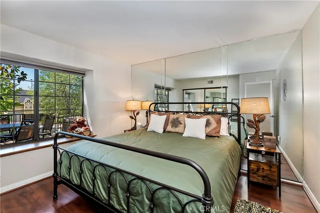 a bedroom with a bed and a large window with balcony view