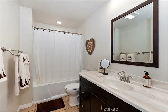 a bathroom with a granite countertop sink mirror vanity and toilet