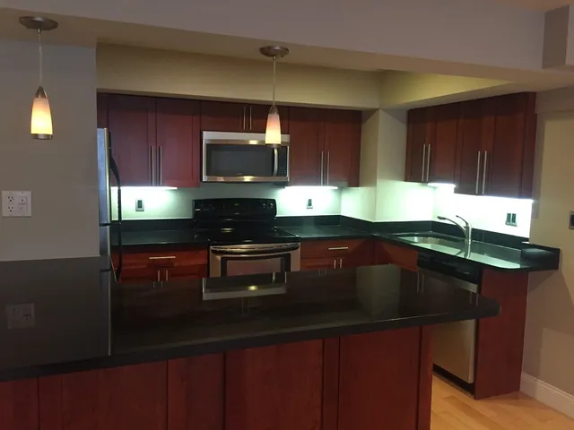a kitchen with a sink a microwave a stove and cabinets