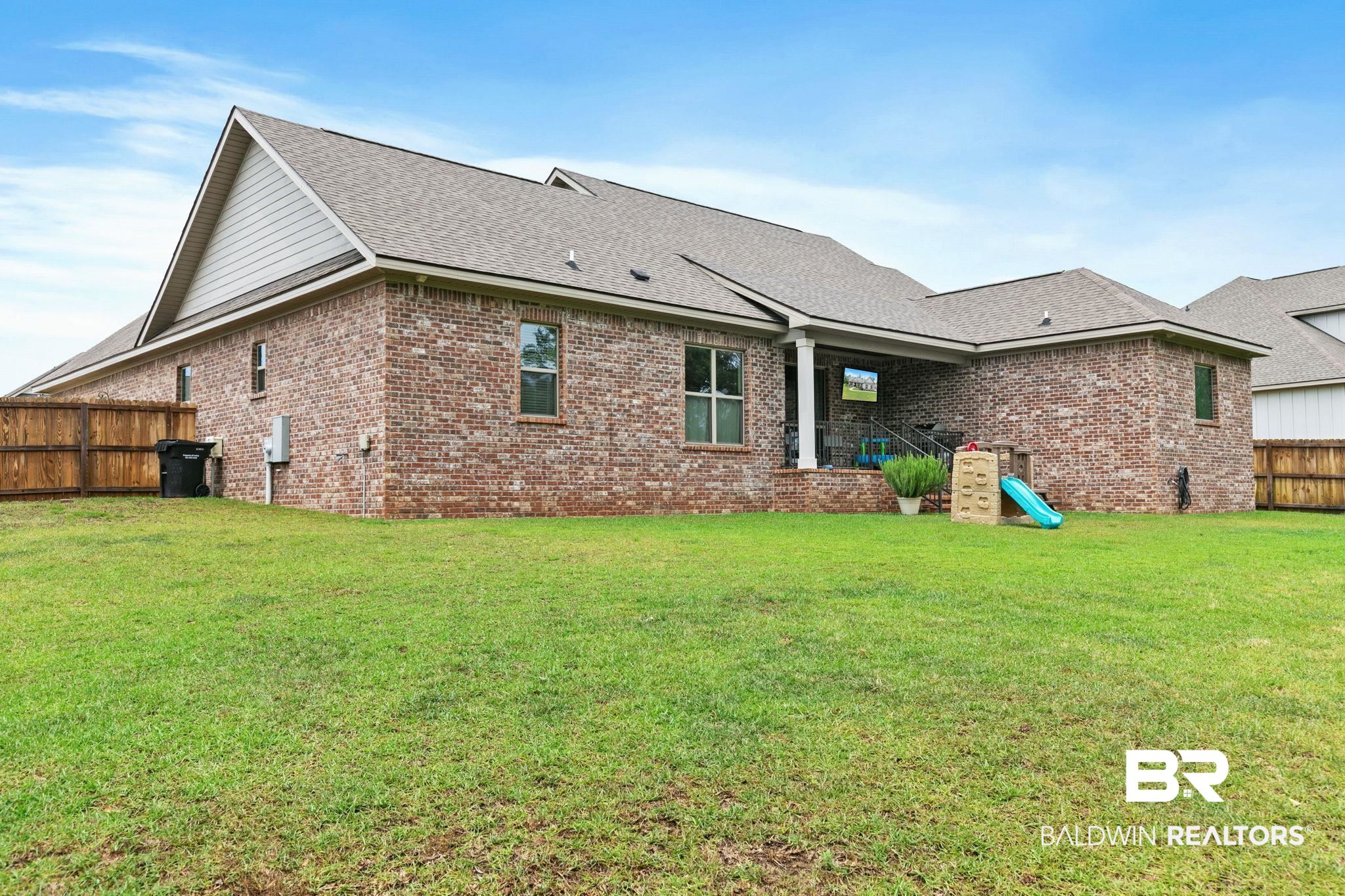 13233 Ibis Boulevard Daphne, AL 36527 - Photo 58 of 100 Spacious backyard featuring a brick exterior and a covered patio area