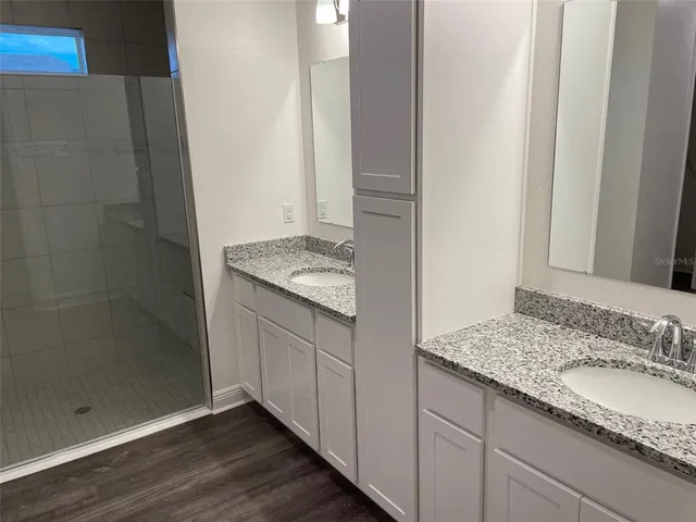 a bathroom with a granite countertop sink and a mirror
