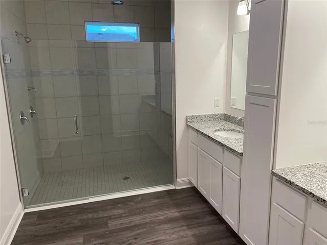 a bathroom with a granite countertop shower a sink and a stove