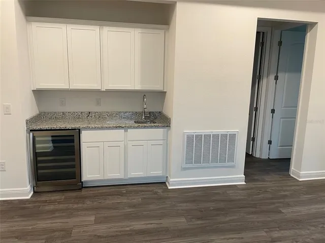 a view of a kitchen with cabinets and wooden floor