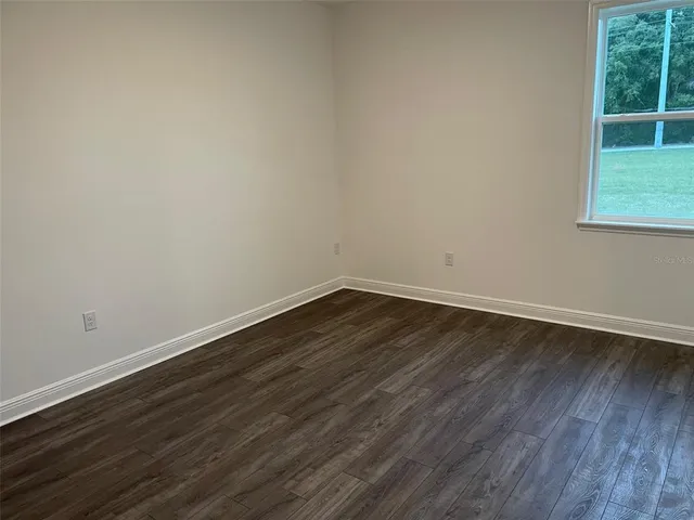 a view of a small space with wooden floor and a window