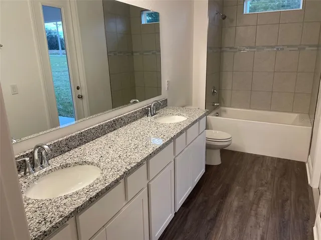 a bathroom with a granite countertop sink and a bathtub