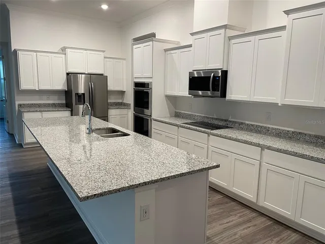 a kitchen with stainless steel appliances granite countertop a sink and a microwave