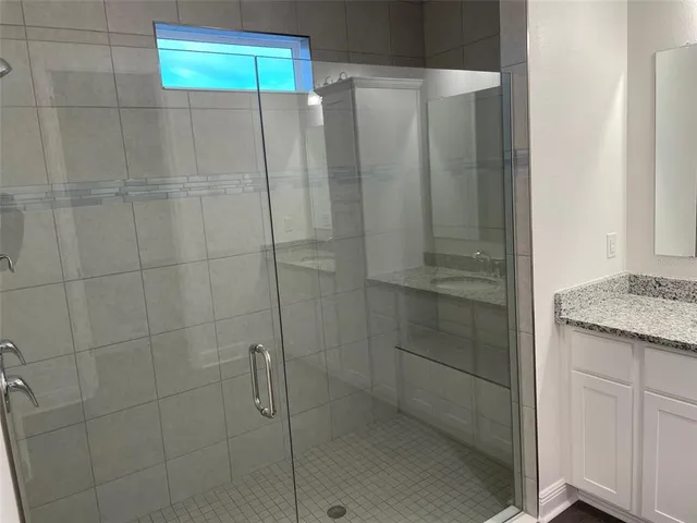 a bathroom with a granite countertop shower and a sink