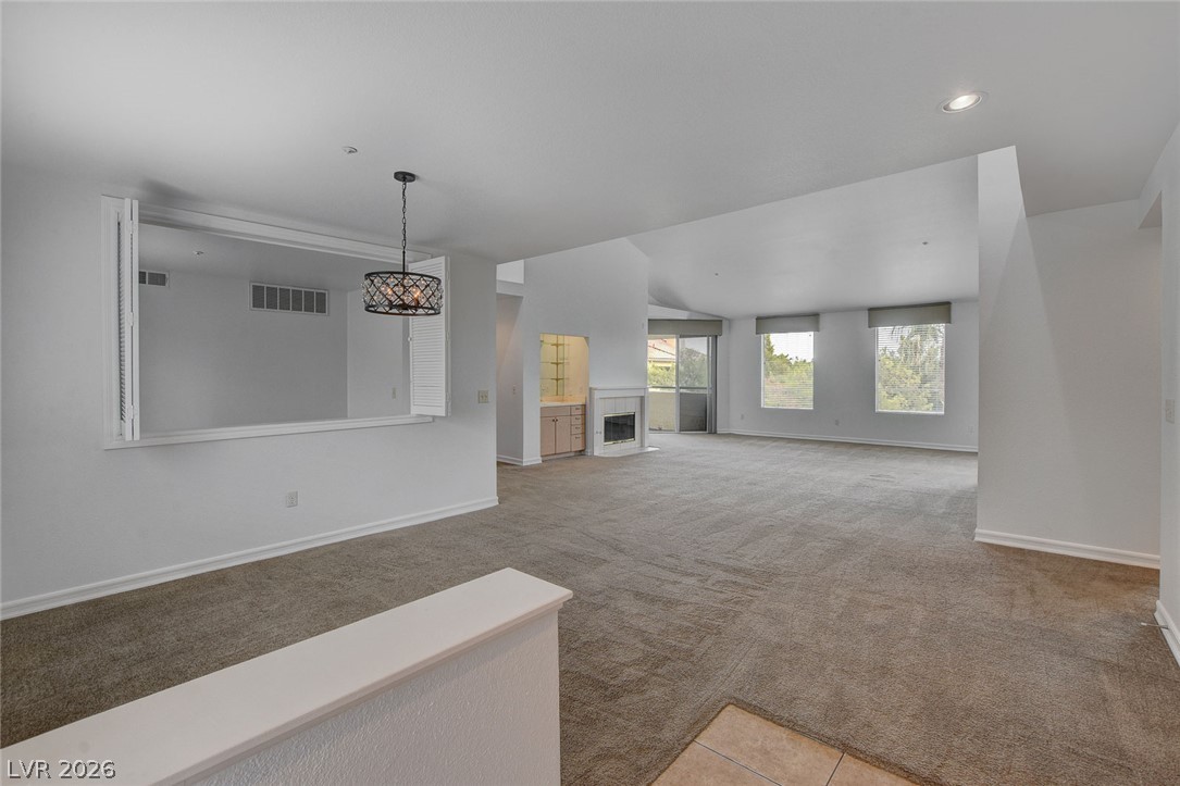 230 East Flamingo Road, Unit 404 Las Vegas, NV 89169 - Photo 3 of 34 A spacious open interior flows from carpeted living areas toward a fireplace and bright windows.