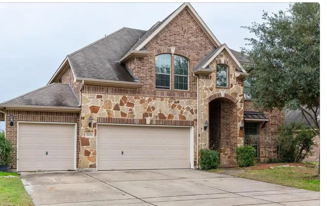 a front view of a house with white fence