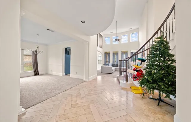 a living room with stairs and a potted plant