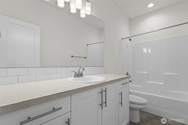 a bathroom with a sink a toilet a tub and shower