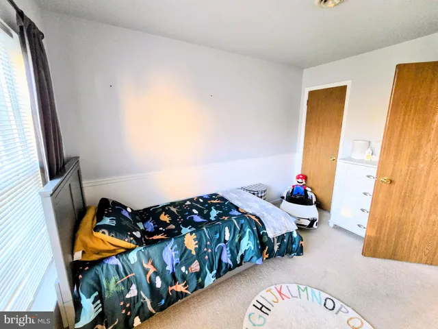 a bedroom with three beds and a window