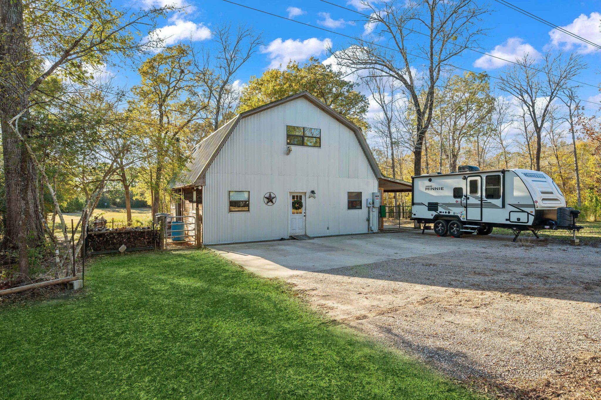 521 Camilla Lake Road Coldspring, TX 77331 - Photo 1 of 34 a view of a white house next to a yard and a large tree