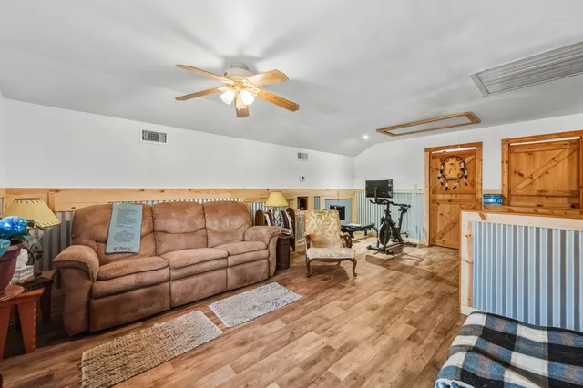 a living room with furniture a couch and paintings on the wall
