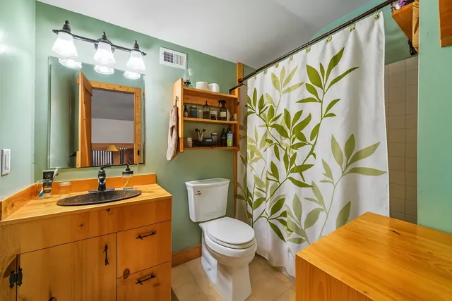 a bathroom with a sink a toilet and a mirror