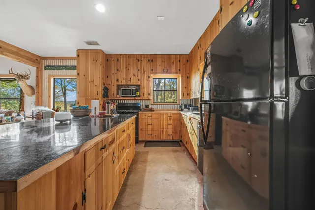 a view of a kitchen with kitchen island a large window a sink and stainless steel appliances