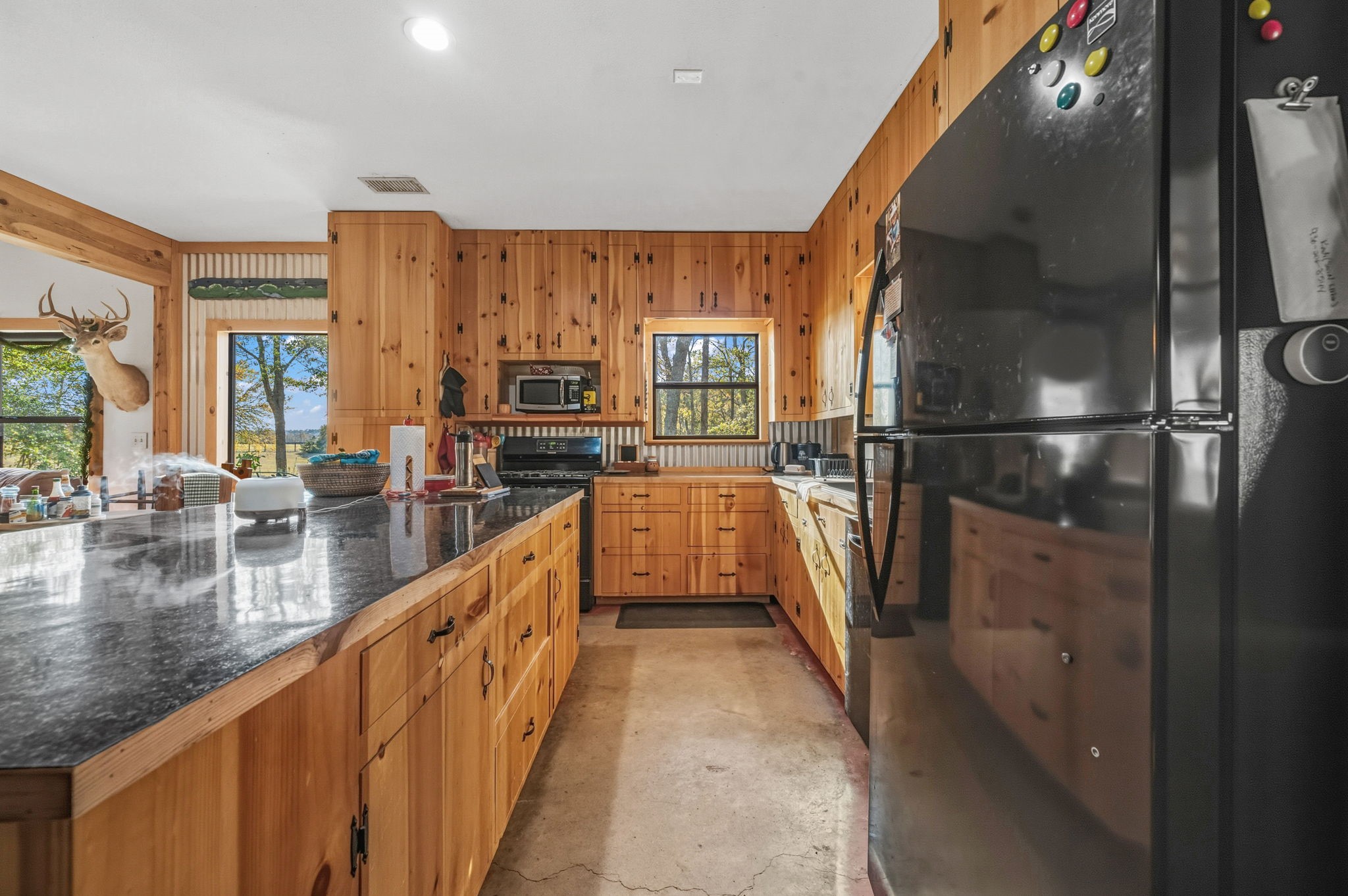 521 Camilla Lake Road Coldspring, TX 77331 - Photo 6 of 34 a view of a kitchen with kitchen island a large window a sink and stainless steel appliances