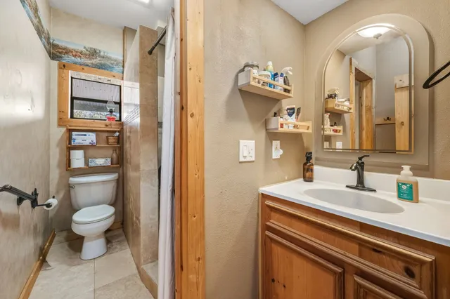 a bathroom with a sink a toilet and a mirror