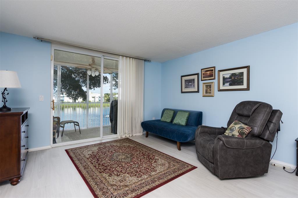 9539 Weldon Circle, Unit F201 Tamarac, FL 33321 - Photo 11 of 33 a living room with furniture and a rug