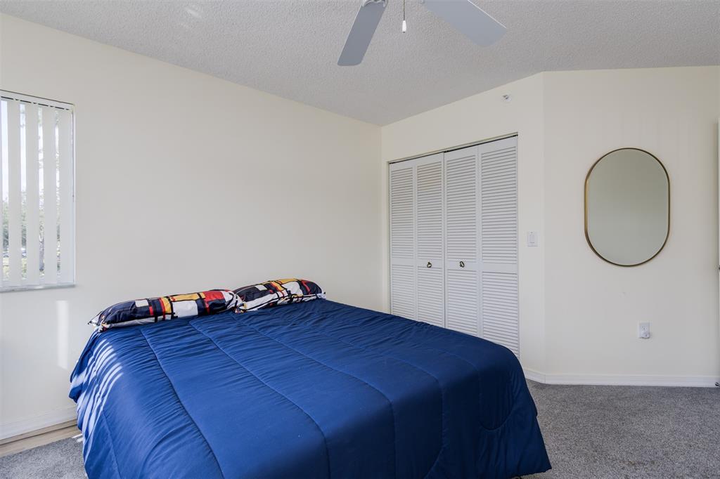 9539 Weldon Circle, Unit F201 Tamarac, FL 33321 - Photo 15 of 33 a bedroom with a bed and window