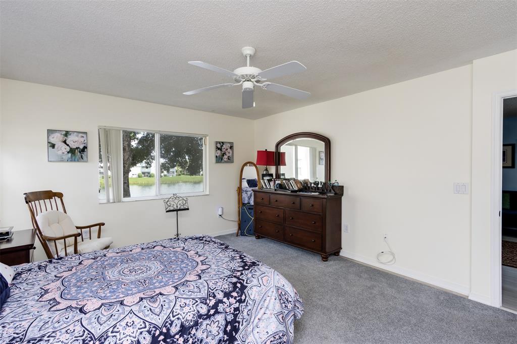 9539 Weldon Circle, Unit F201 Tamarac, FL 33321 - Photo 20 of 33 a bedroom with a bed and a dresser in it