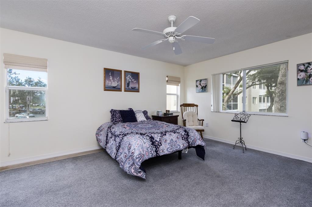 9539 Weldon Circle, Unit F201 Tamarac, FL 33321 - Photo 21 of 33 a bedroom with a bed and a chandelier