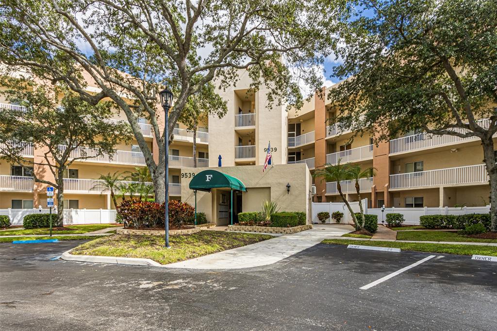 9539 Weldon Circle, Unit F201 Tamarac, FL 33321 - Photo 28 of 33 a front view of a building with street view and trees