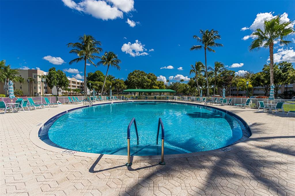 9539 Weldon Circle, Unit F201 Tamarac, FL 33321 - Photo 30 of 33 a swimming pool with trees in the background