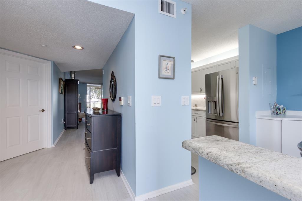 9539 Weldon Circle, Unit F201 Tamarac, FL 33321 - Photo 7 of 33 a kitchen with stainless steel appliances granite countertop a refrigerator and a sink
