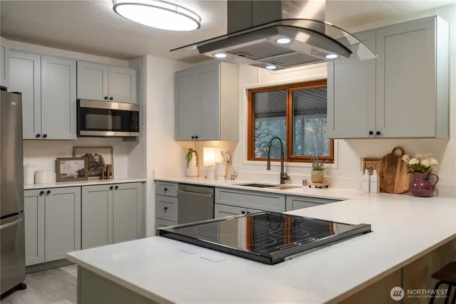 a kitchen with kitchen island granite countertop a sink stainless steel appliances and cabinets