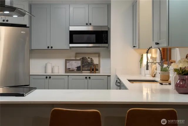 a kitchen with stainless steel appliances granite countertop a refrigerator and a sink