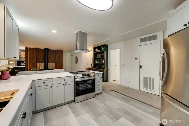 a large kitchen with a sink stainless steel appliances and cabinets