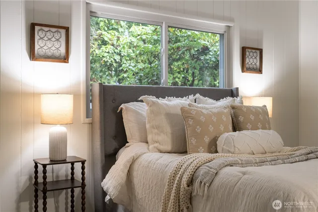 a bed sitting in a bedroom next to a window