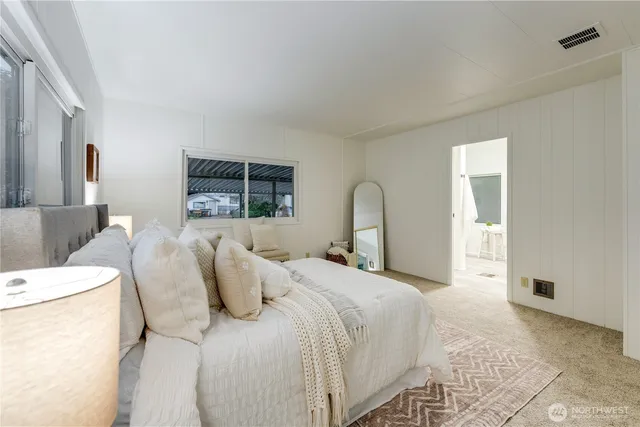 a bedroom with a bed and a large mirror