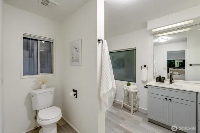 a bathroom with a toilet sink and mirror