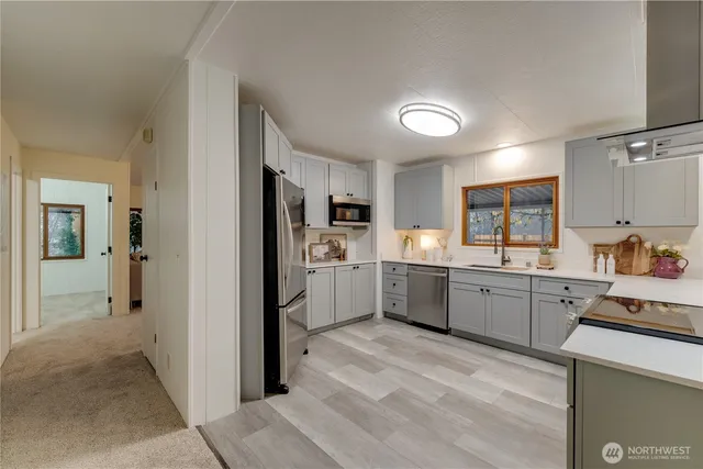 a kitchen with a refrigerator a sink counter top space and cabinets