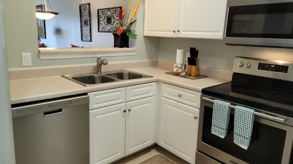 a kitchen with granite countertop white cabinets and white appliances
