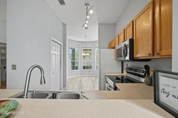 a kitchen with stainless steel appliances a refrigerator sink and microwave