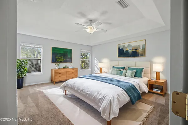 an empty room with windows and chandelier fan