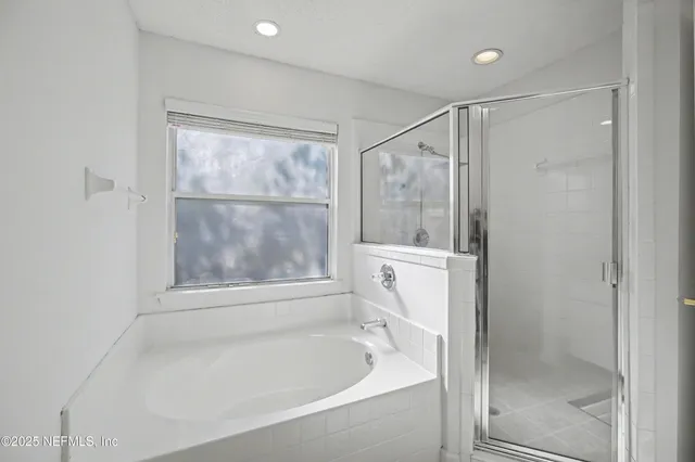 a view of an empty room with window and a ceiling fan