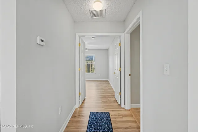 a view of a hallway with wooden shelves