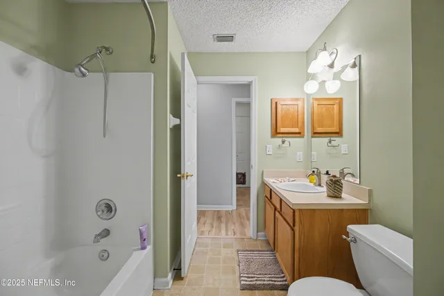 a view of an empty room with chandelier fan