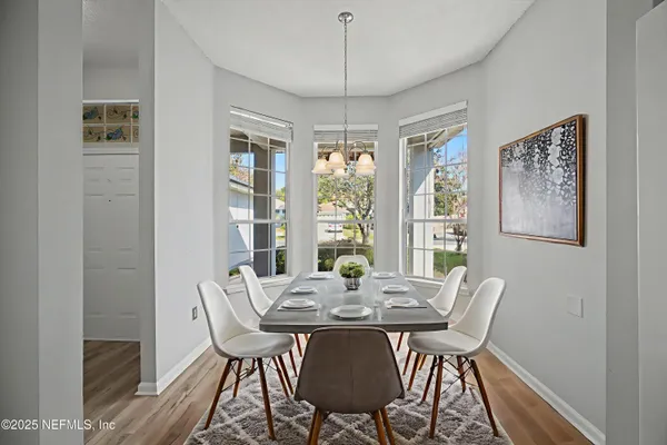 a view of an empty room with windows and chandelier