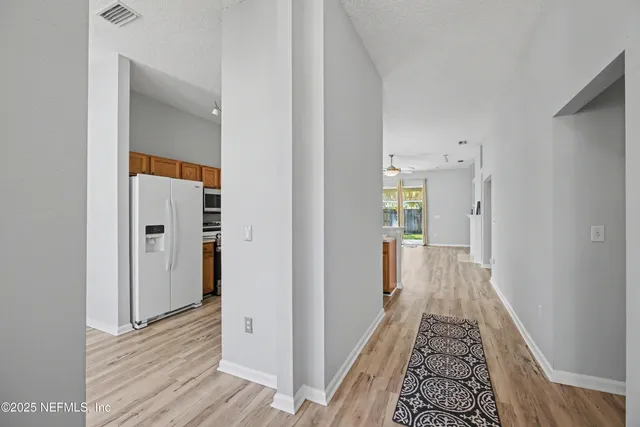 a view of a hallway with wooden floor and staircase
